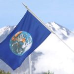 The Earth flag is presented on stage at Fuji Sanctuary, with Mount Fuji in the background.